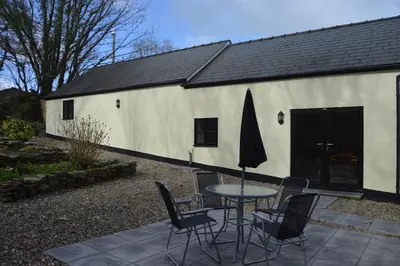 a table and chairs in front of a white building at Dog friendly rural location in Llanerch-Aeron