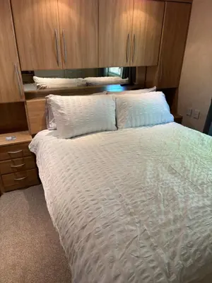a bedroom with a large bed with wooden cabinets at The Panorama View Luxury Retreat in Aberystwyth in Aberystwyth
