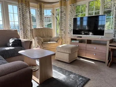 a living room with a flat screen tv and furniture at The Panorama View Luxury Retreat in Aberystwyth in Aberystwyth