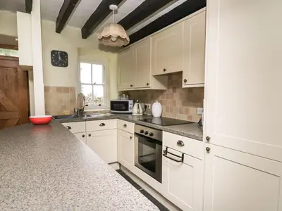 a kitchen with white cabinets and a counter top at Tyn Y Graig in Arthog