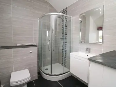 a bathroom with a shower and a toilet and a sink at Tyn Y Graig in Arthog