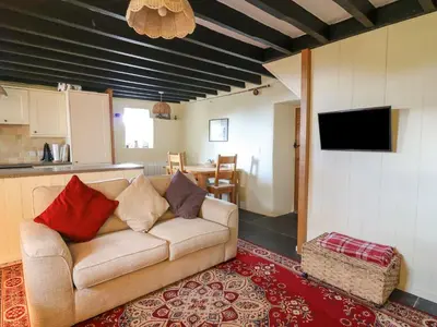 a living room with a couch and a kitchen at Tyn Y Graig in Arthog