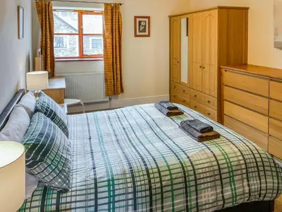 a bedroom with a bed and a wooden dresser at Bron-Yr-Aur - Uk49616 in New Quay
