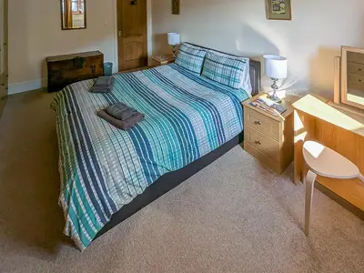 a bedroom with a bed with a dresser and a desk at Bron-Yr-Aur - Uk49616 in New Quay
