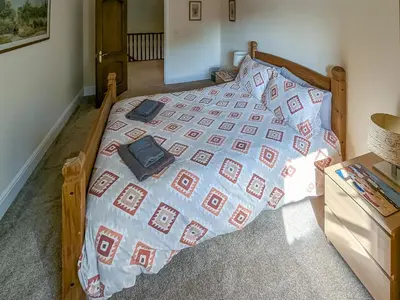 a bed with a blue and red quilt on it at Bron-Yr-Aur - Uk49616 in New Quay
