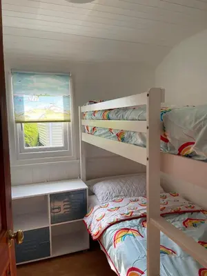 a bedroom with two bunk beds and a window at Awel Mor Beautiful Pet Friendly Chalet in Clarach Bay in Aberystwyth