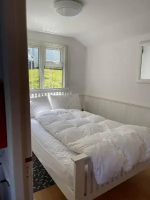 a white bed in a room with a window at Awel Mor Beautiful Pet Friendly Chalet in Clarach Bay in Aberystwyth
