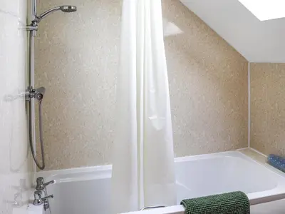 a bathroom with a shower with a white tub at Teifi Cottage - Uk49590 in Llansawel
