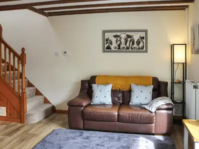 a living room with a brown leather couch at Teifi Cottage - Uk49590 in Llansawel