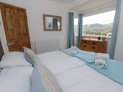 two twin beds in a bedroom with a window at Brycheiniog View in Brecon