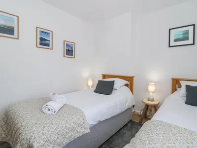 two beds in a room with white walls at Brycheiniog View in Brecon