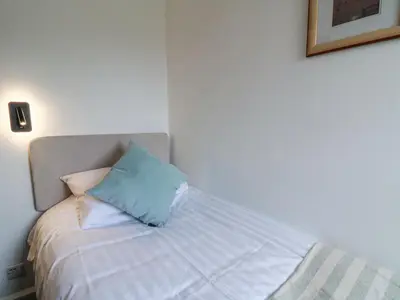 a bed with a blue pillow on top of it at Brycheiniog View in Brecon