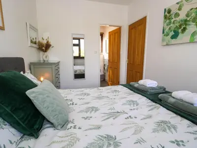 a bedroom with a large bed with green pillows at Gilfach Bach in Dolgellau
