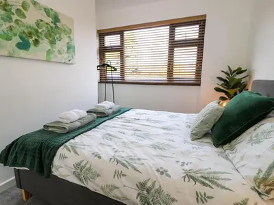 a bedroom with a bed with green plants on it at Gilfach Bach in Dolgellau