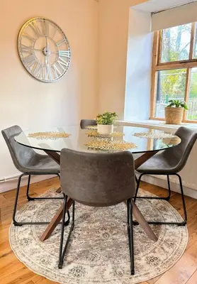 a dining room with a glass table and two chairs at Charming Stone Cottage Getaway in Dolgellau
