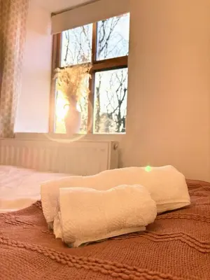 a bedroom with two towels on a bed with a window at Charming Stone Cottage Getaway in Dolgellau