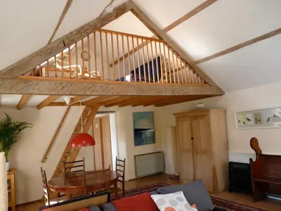a living room with a wooden staircase in a house at Pretty sunny cottage, Machynlleth in Machynlleth
