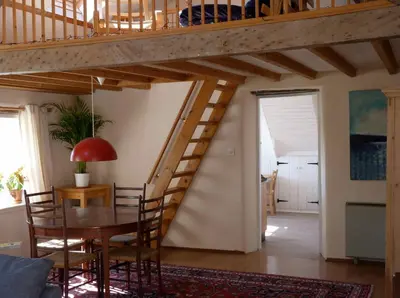 a wooden staircase in a living room with a table and chairs at Pretty sunny cottage, Machynlleth in Machynlleth