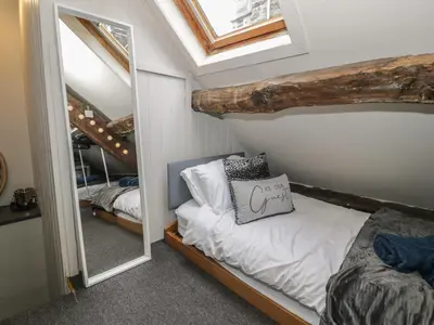 a bedroom with a bunk bed and a mirror at Penygrisiau in Barmouth