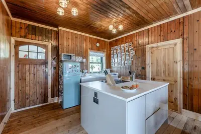 a kitchen with wooden walls and a blue refrigerator at 3 Bed in Barmouth oc-c31942 in Barmouth