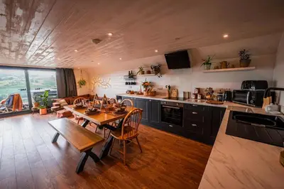 a kitchen and dining room with a table and chairs at Oolert Treehouse in Hundred House