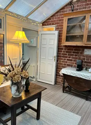a room with a table with a vase of flowers at Oaklands Farm in Preesgreen