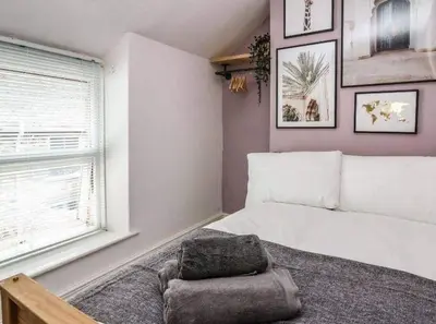 a bedroom with a large bed and a window at Beautiful cottage with log burner in Dolgellau