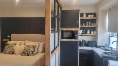 a small room with a bed and a kitchen at The Old Shop High Street in Llanidloes