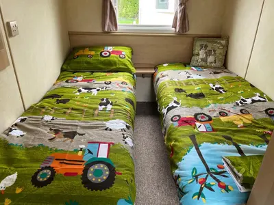two beds in a small room with two bedsskirts at Sylvan Near Hay on Wye in Rhos-gôch