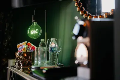 a table with glasses and bottles on a green wall at Unique Shrewsbury Rooms in Shrewsbury