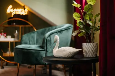 a swan sitting on a table next to a green chair at Unique Shrewsbury Rooms in Shrewsbury