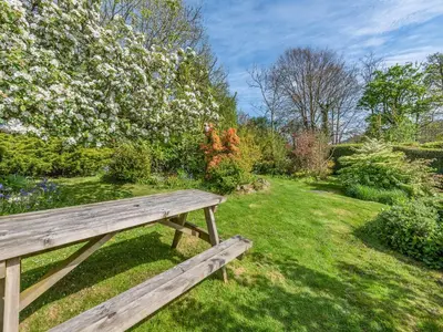 a wooden bench sitting in a garden with flowers at West Llwyn - Uk41757 in Rhyd Owen