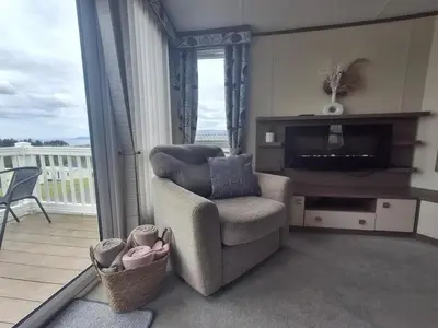 a living room with a chair and a television at 'Falcons Rest' in Borth