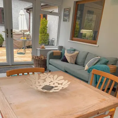 a living room with a table and a couch at Cysgod Bach & Caban y Saer Cottages in Bala