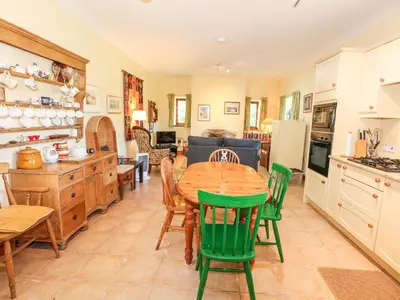 a kitchen and dining room with a table and chairs at Cae'n Y Coed Barn in Talsarnau