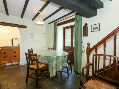 a dining room with a table and chairs at Cae'n Y Coed Cottage in Talsarnau