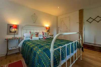 a bedroom with a bed with a green and yellow blanket at Beudy-Mach in Cemmaes Road
