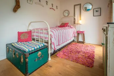 a bedroom with a bed and a pink rug at Beudy-Mach in Cemmaes Road