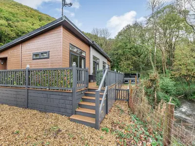 a house with a fence and a wooden house at The Powys Lodge in New Quay