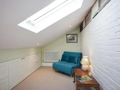 a living room with a blue chair and a table at The Vinery - Uk49583 in Shrewsbury