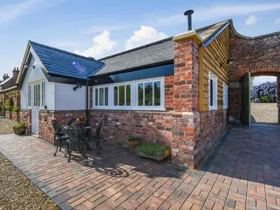 a brick house with a patio with a table at The Vinery - Uk49583 in Shrewsbury