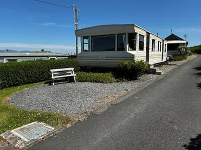 a bench sitting on the side of a road at Northfield Holiday Park in Borth