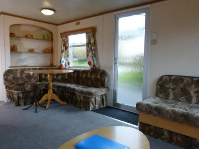 a living room with a couch and a table at Northfield Holiday Park in Borth