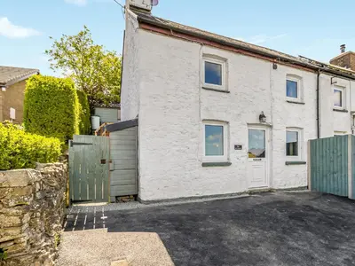 a white house with a gate and a garage at 3 Legged Duck Cottage in Yspytty-Ystwyth