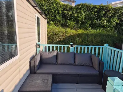 a couch sitting on the back of a porch at Caravan in Picturesque New Quay Wales in New Quay