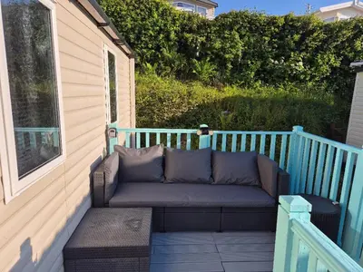 a couch sitting on the side of a porch at Caravan in Picturesque New Quay Wales in New Quay