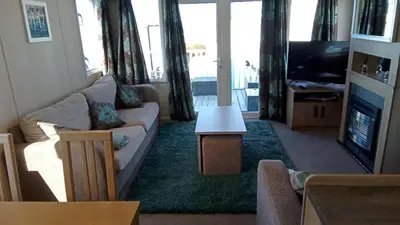 a living room with a couch and a tv at Caravan in Picturesque New Quay Wales in New Quay