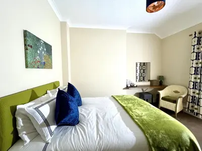 a bedroom with a bed with a green headboard at Lion Royal Hotel, Rhayader in Rhayader