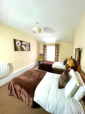 a bedroom with two beds and a window at Lion Royal Hotel, Rhayader in Rhayader