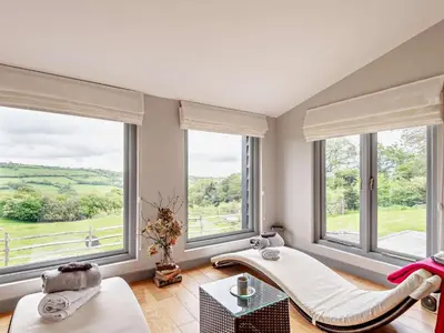 a living room with two white chairs and large windows at 2 Bed in Hereford oc-42881 in Craswall